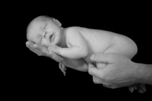 Man's Hands Holding Infant